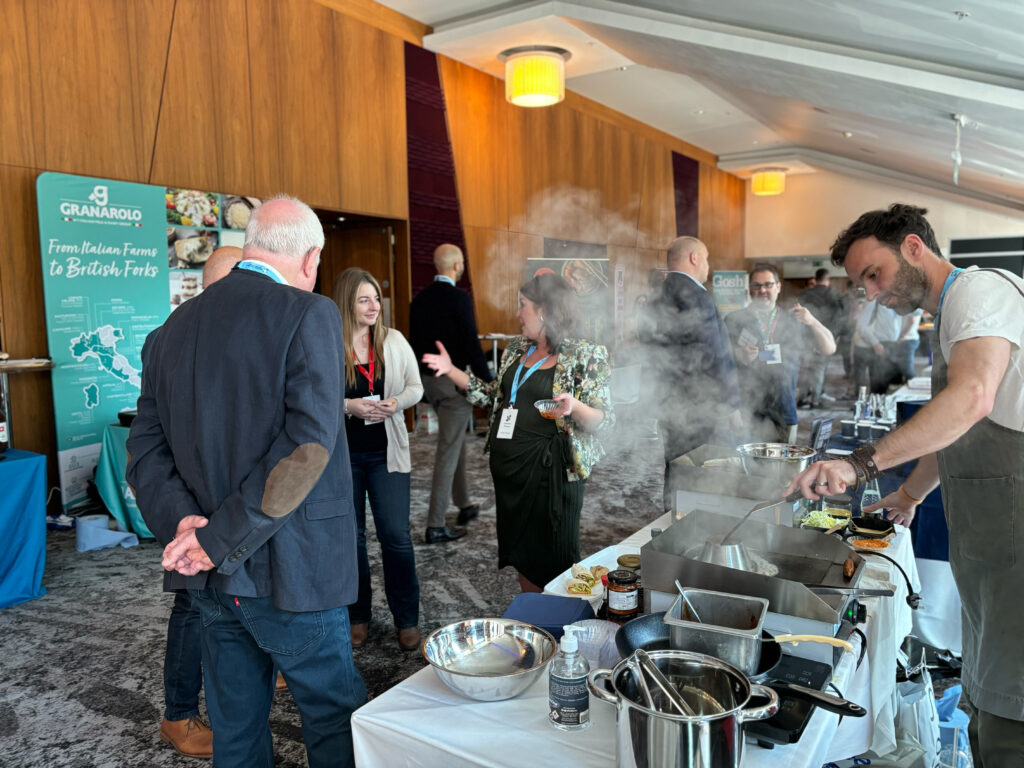 catering supplier cooking food product for buyer in meeting at showcase stand